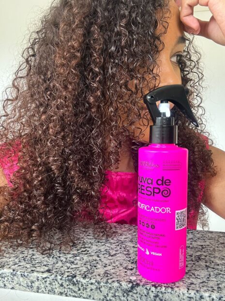 Mulher negra de blusa com cor pink, mostrando o resutado dos cabelos cacheados  junto com o Umidificador Forever Liss Chuva de Crespo 