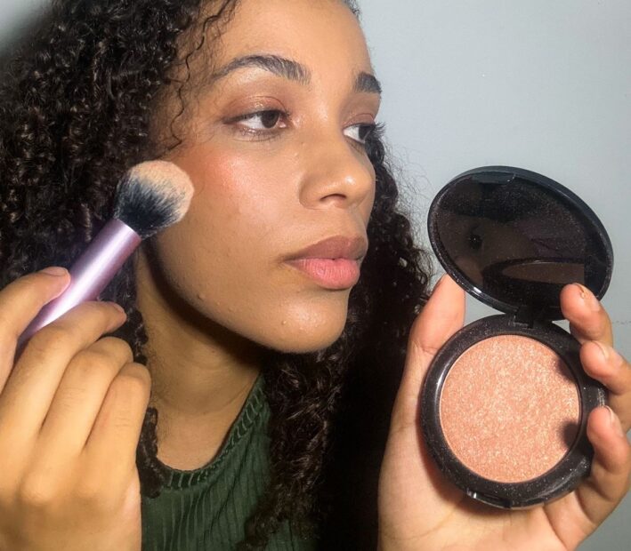 mulher negra se maquiando com uma ótima preparação de pele