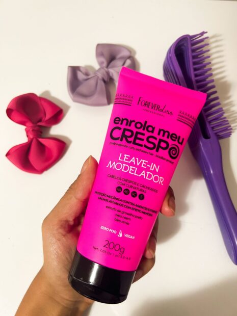 creme Leave-in da Forever Liss enrola meu crespo, dois lacinhos de cabelo um rosa e outro roxo. E uma escova polvo roxa.